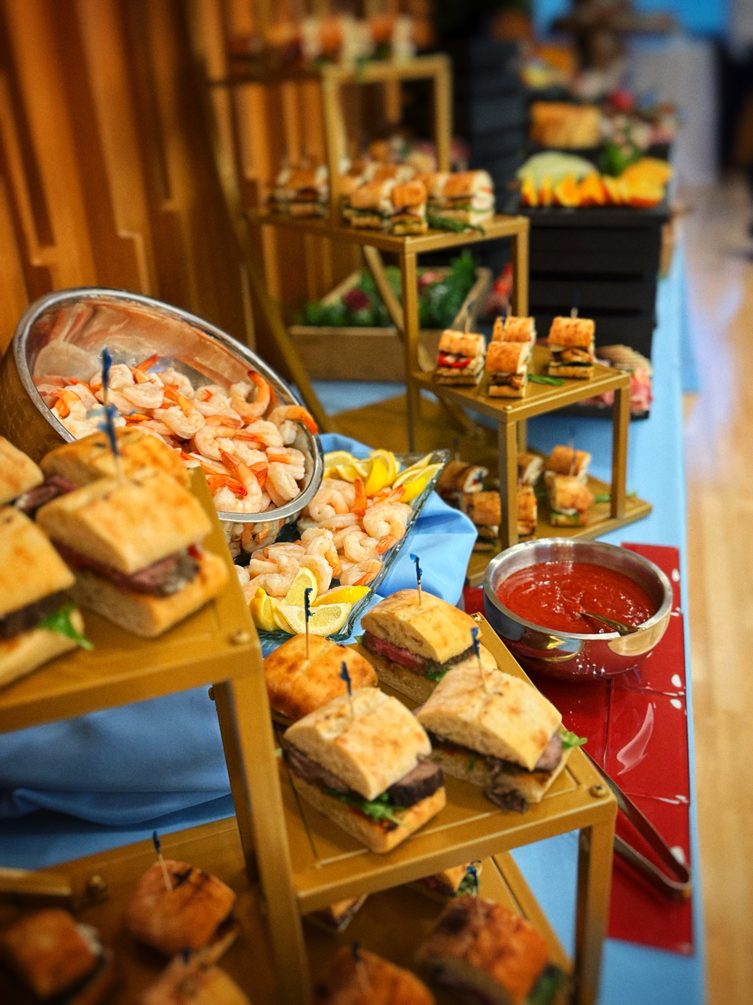 Two Guys Catering stationary display of shrimp cocktail and sliders on tiered stands