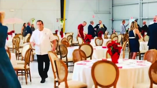 The Two Guys team and dining tables inside Elite Jets Hangar in Naples