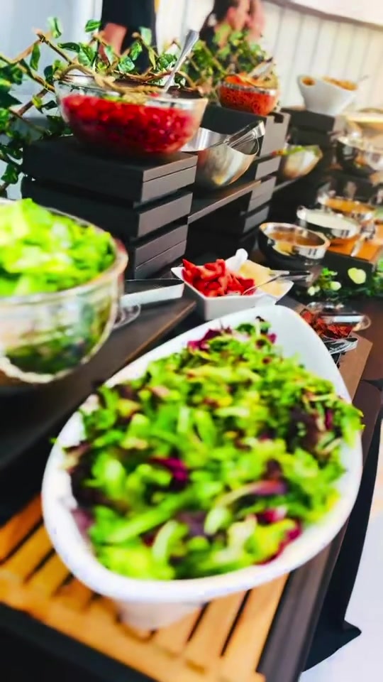 Salad toppings arranged on a tiered food display at Elite Jets