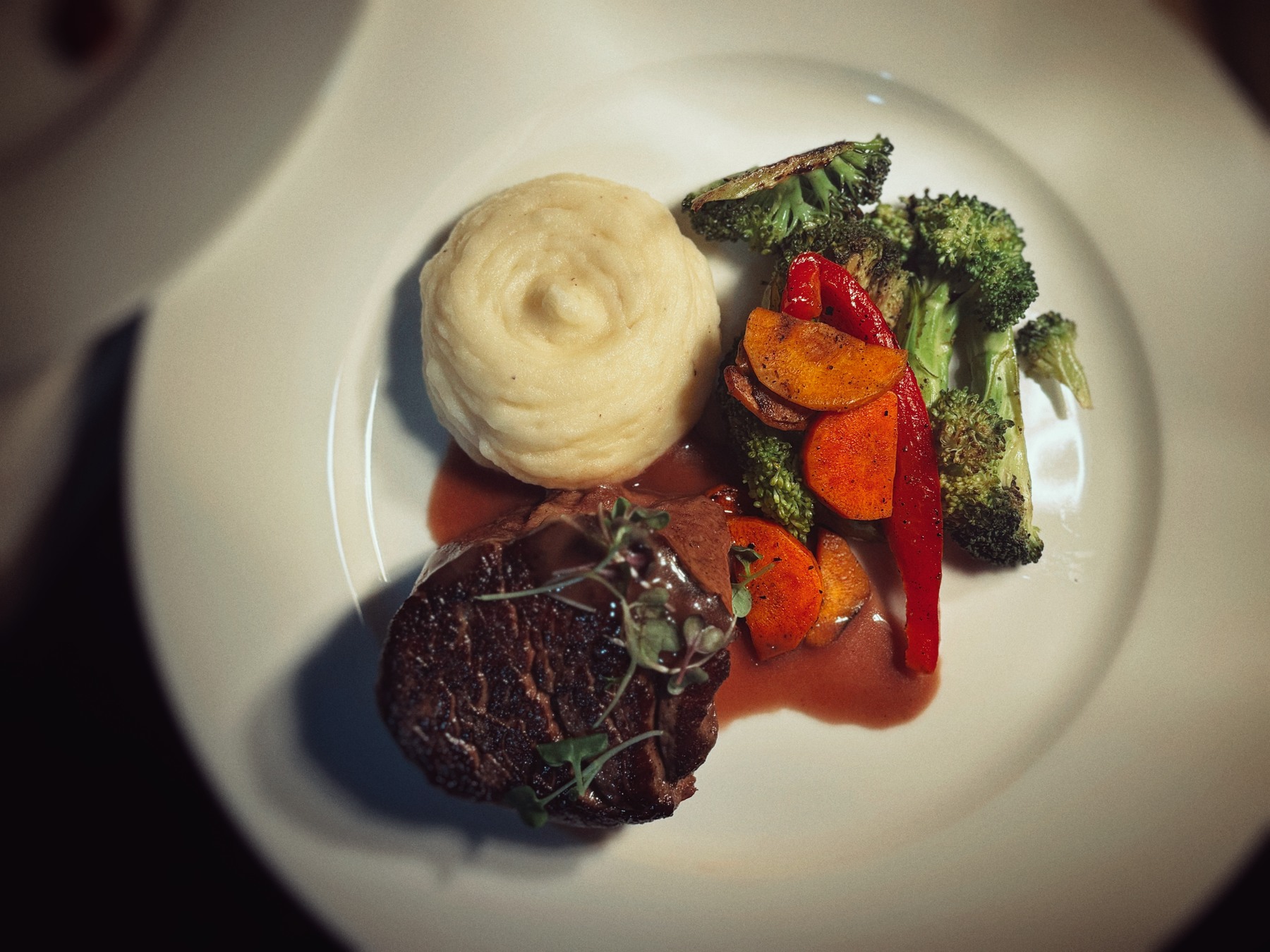 Filet mignon medallions plated with whipped potatoes and roasted vegetables for the gala